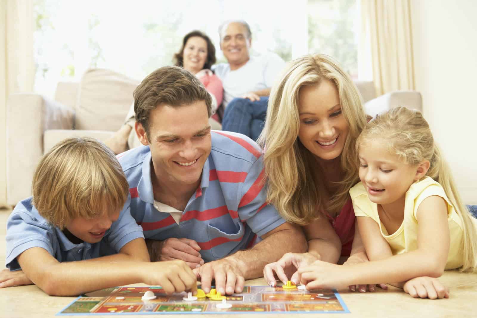 Grandparents, Parents, And Children Putting A Puzzle Together.