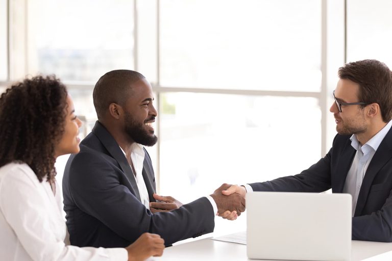 A Young Couple In A Law Office Shake Hands With Their Estate Planning Attorney