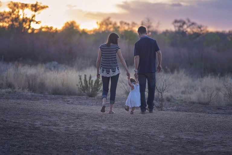 A Mother And Father Walk With Their Child