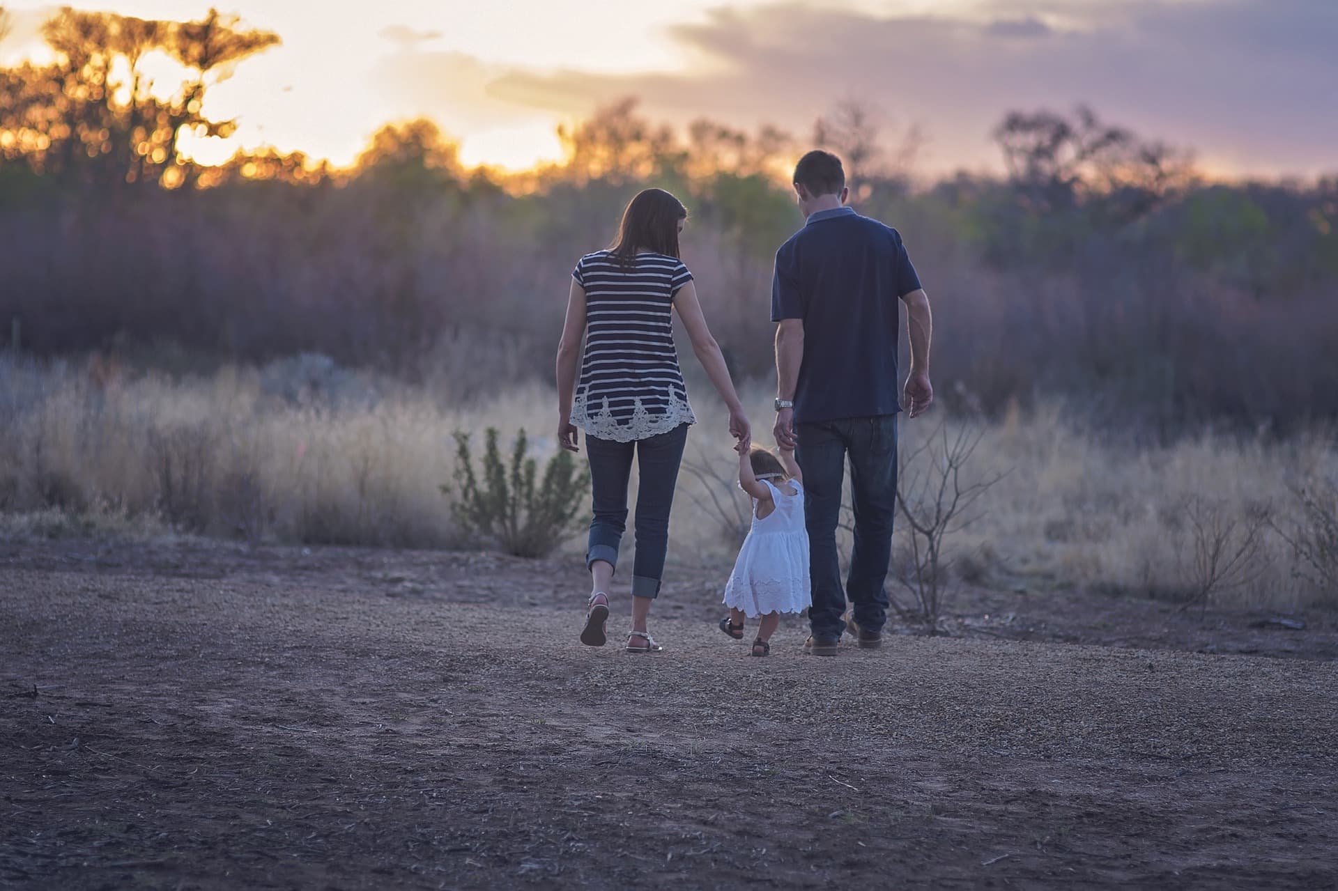 A mother and father walk with their child