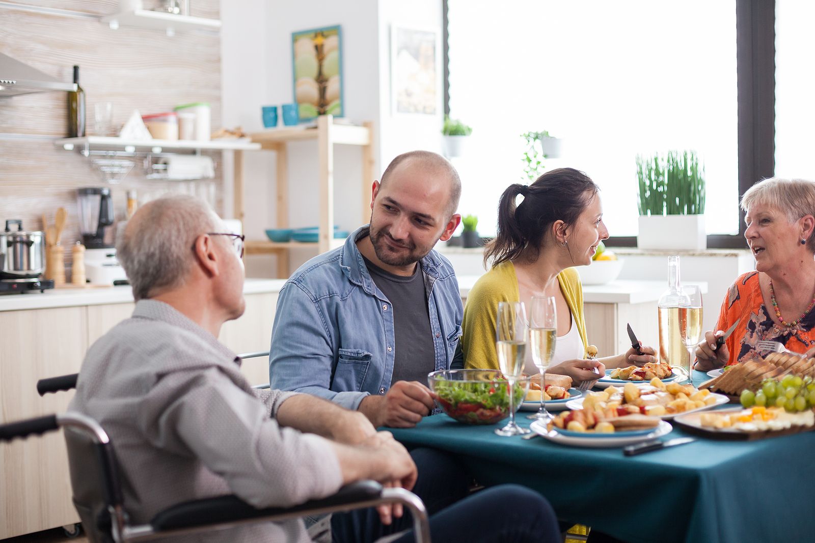 A family sitting at the dinner table, an older man at the head